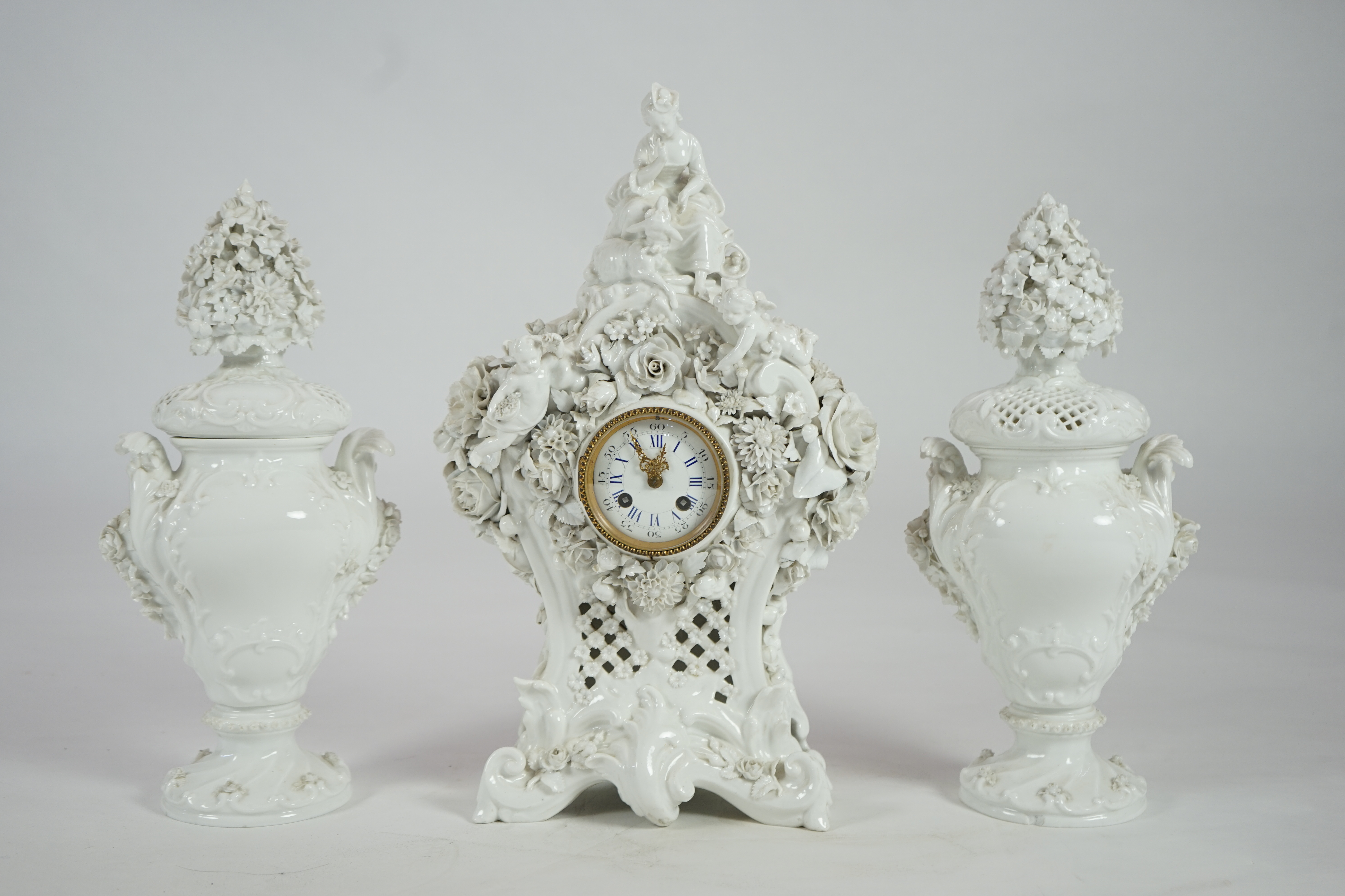 Vion & Baury. A 19th century Meissen style white glazed porcelain three piece clock set